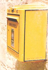Yellow POSTES box attached to a wall.