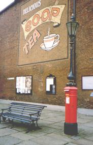 Red pillar box with a lamp post on top.