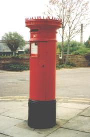 Red pillar box with spikes on cap.